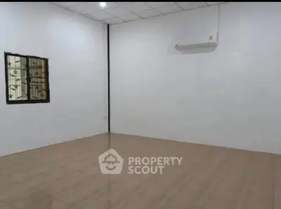 Spacious empty room with tiled flooring and air conditioning, ideal for customization.