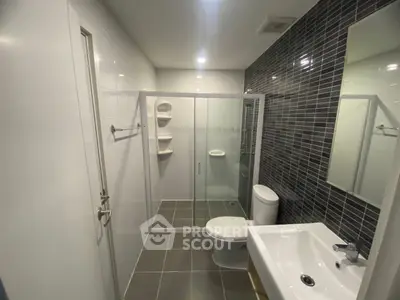 Modern bathroom with sleek glass shower and contemporary fixtures.