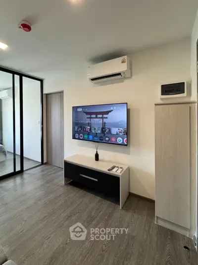 Modern living room with sleek TV setup and air conditioning, perfect for relaxation.