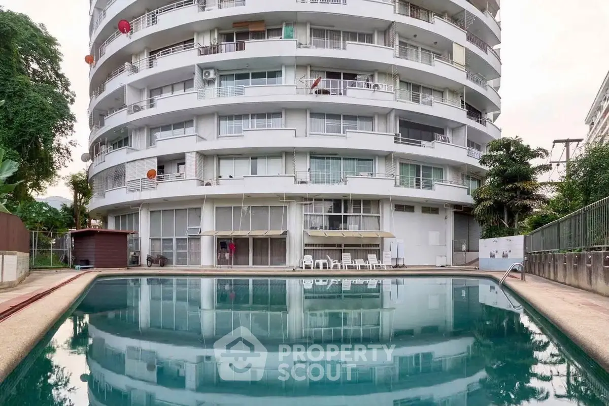 Stunning apartment building with poolside view and lush greenery