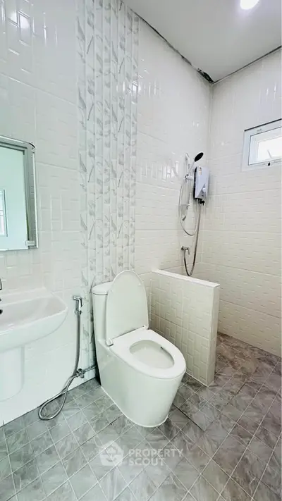 Modern bathroom with white tiles and shower in real estate property.