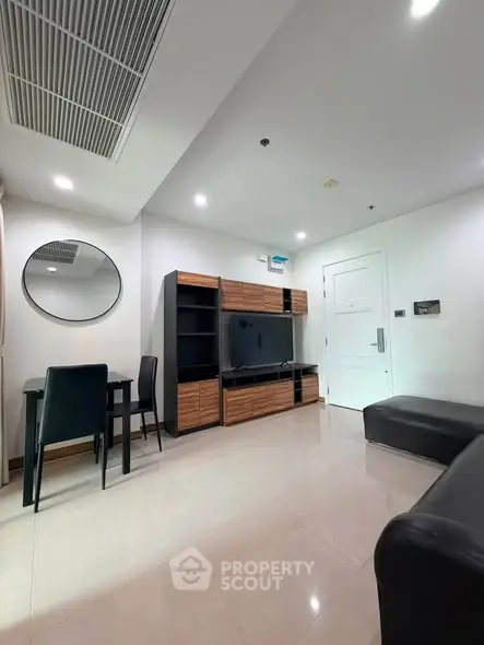 Modern living room with sleek furniture and wall-mounted TV in a stylish apartment.