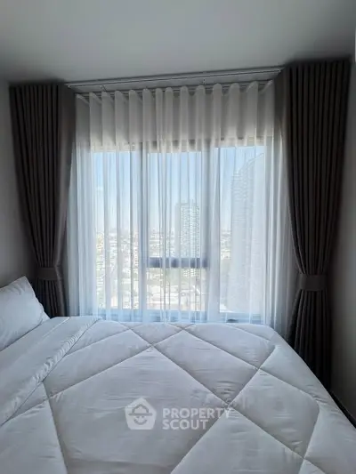 Bright bedroom with large window offering stunning city view, elegant curtains, and cozy bedding.
