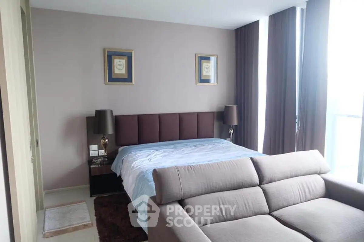 Spacious bedroom with modern decor and large windows for natural light