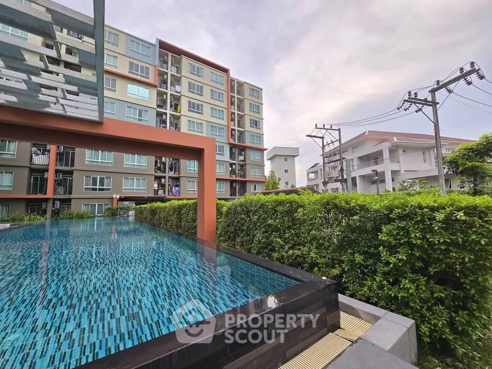 Modern apartment building with a stylish pool and lush greenery, perfect for urban living.