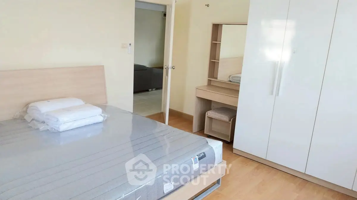 Spacious bedroom with modern furniture and ample storage in a stylish apartment.