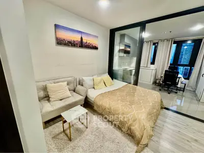 Modern studio apartment with cozy living area and city view, featuring a comfortable sofa and stylish decor.