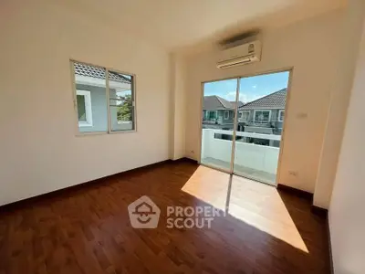 Bright bedroom with wooden flooring and balcony access in modern home