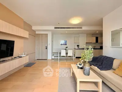 Spacious modern living room with open kitchen and stylish decor in a contemporary apartment.