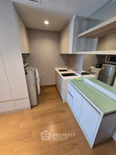 Modern kitchen with sleek cabinetry and appliances in compact layout