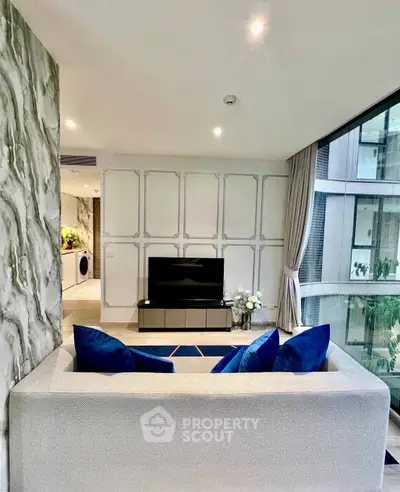 Modern living room with elegant decor and large windows offering a stunning view.