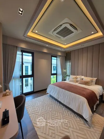 Luxurious bedroom with elegant decor and large windows offering natural light.