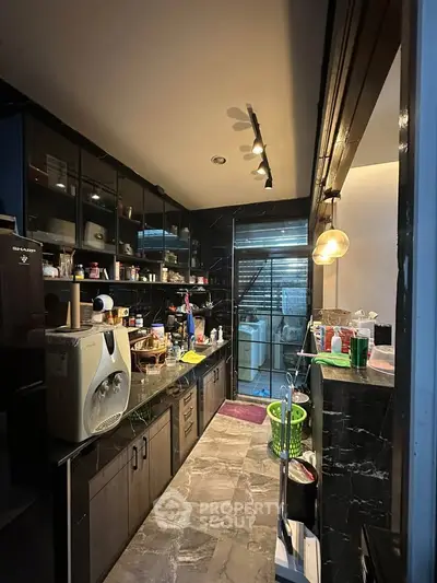 Modern kitchen with sleek cabinets and stylish lighting, featuring a compact yet functional layout.