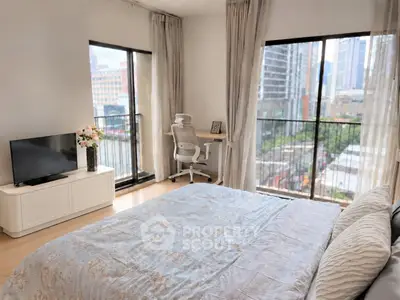 Modern bedroom with city view, featuring a cozy bed, TV, and a stylish work desk by the window.
