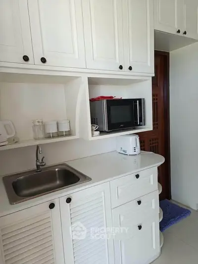 Charming kitchen with white cabinetry and modern appliances, perfect for culinary enthusiasts.