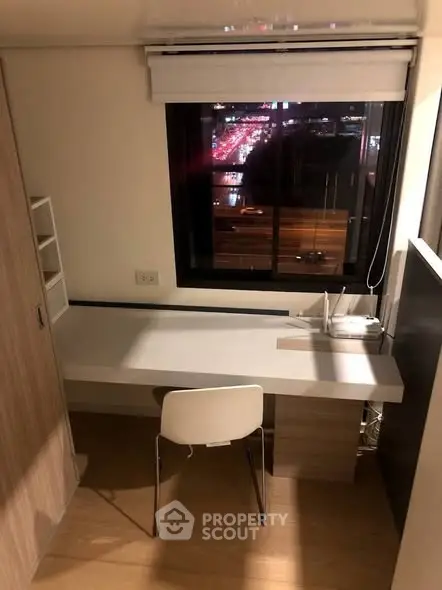 Modern study room with city view, featuring sleek desk and chair, ideal for productivity.