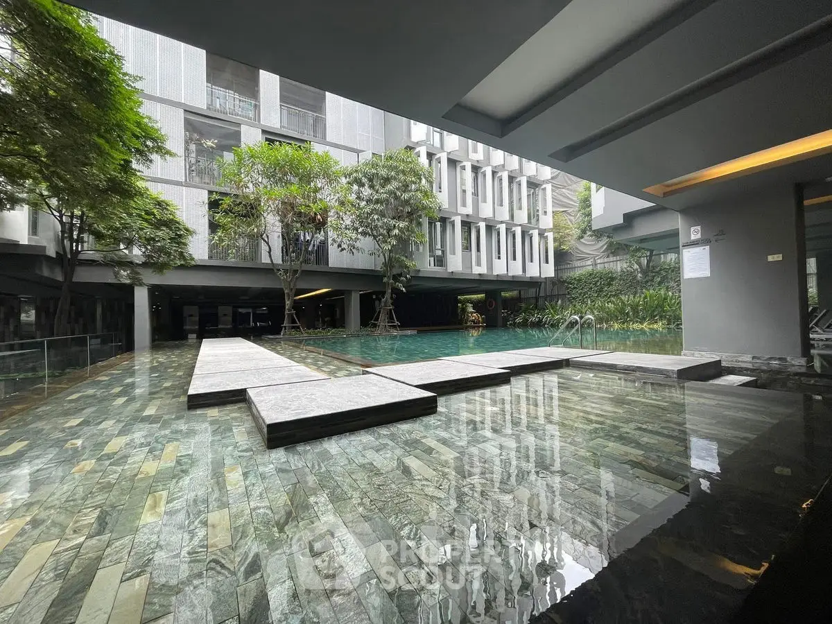 Modern apartment complex with luxurious pool and lush greenery