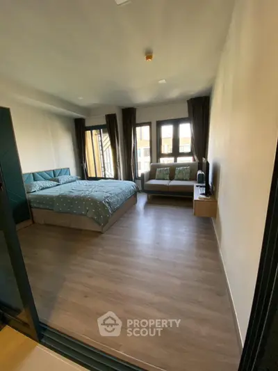 Spacious bedroom with modern decor and large windows for natural light.