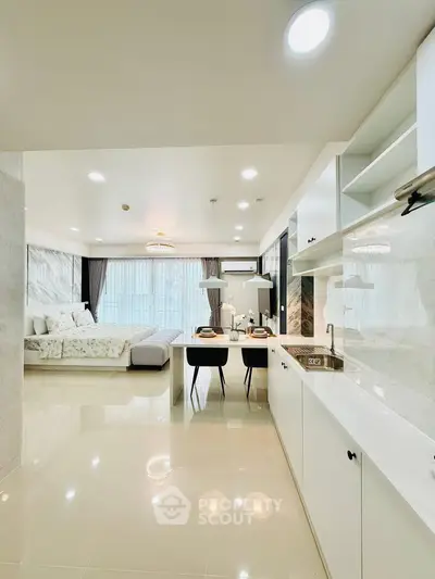 Luxurious open-plan living room and kitchen with elegant decor and ample natural light.