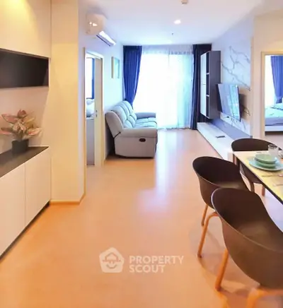 Modern open-plan living room with stylish dining area and cozy seating, featuring natural light and elegant decor.