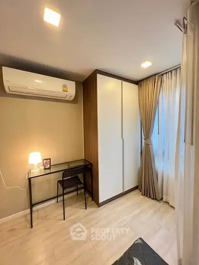Modern bedroom with air conditioning and stylish furniture, featuring a sleek wardrobe and elegant curtains.