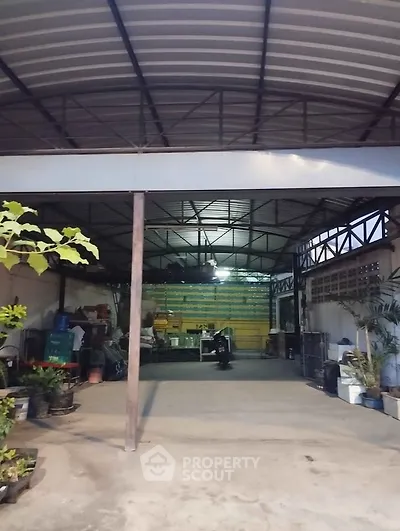 Spacious industrial-style garage with high ceiling and ample storage space.
