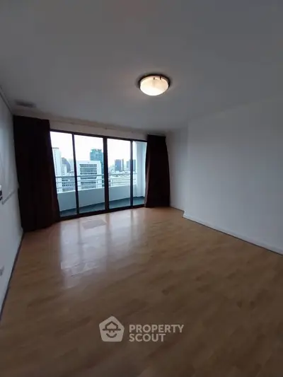 Spacious empty room with large windows and city view, perfect for customization.