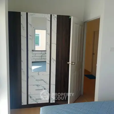 Modern bedroom with stylish wardrobe and open door view