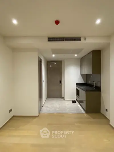 Modern minimalist kitchen with sleek cabinetry and open layout in a contemporary apartment.