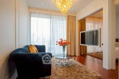 Luxurious living room with plush sofa, elegant chandelier, and city view through large windows.