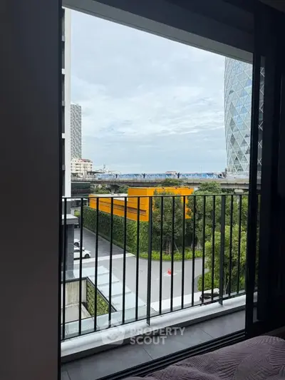 Modern apartment balcony with city view and lush greenery, perfect for urban living.