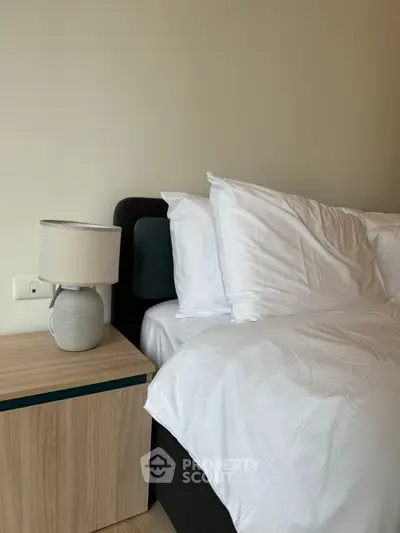 Cozy bedroom with modern bedside table and elegant lamp, perfect for relaxation and comfort.