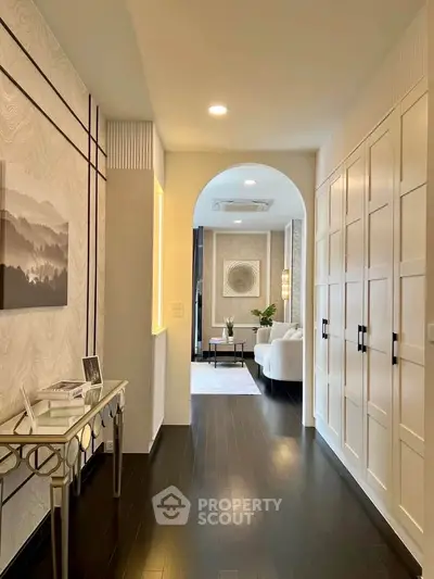Elegant hallway leading to a stylish living room with modern decor and soft lighting.
