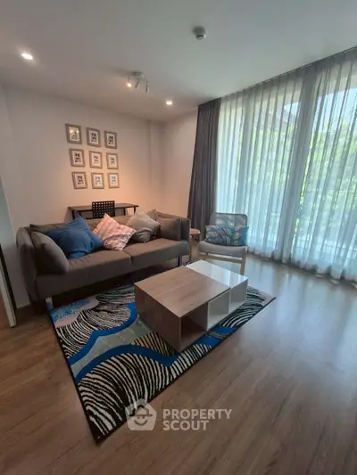 Stylish living room with modern decor, large windows, and cozy seating area.