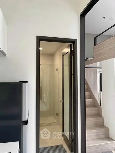 Modern compact living space with sleek bathroom and stylish loft stairs.