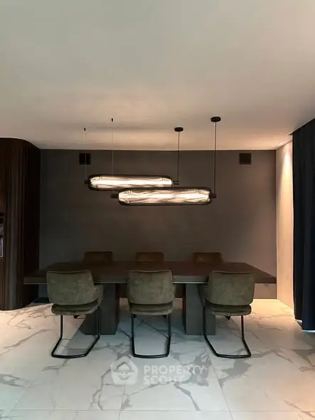 Modern dining room with elegant lighting and stylish chairs on marble flooring.