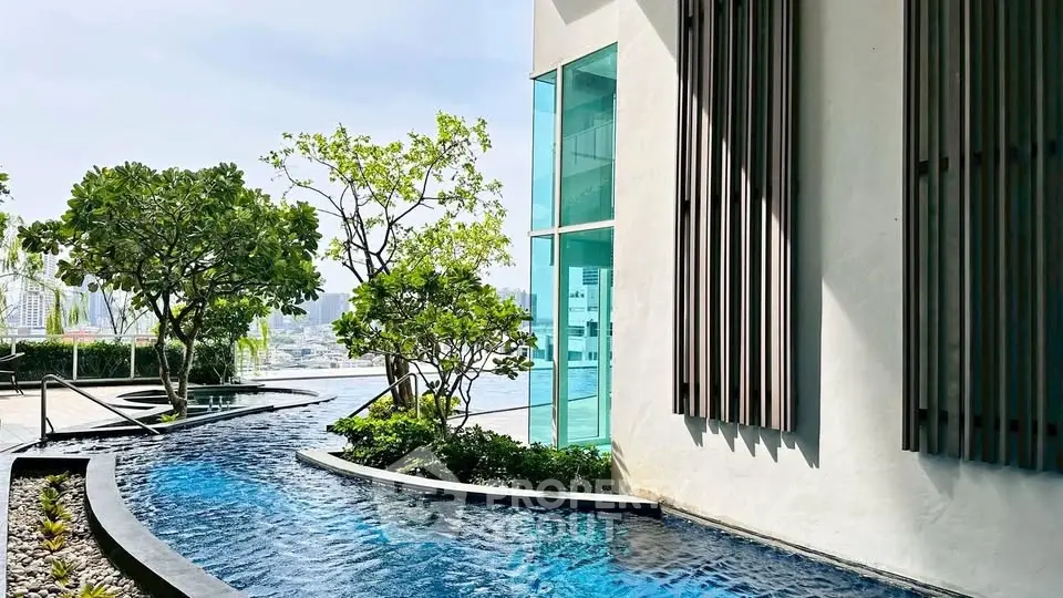 Luxurious modern building with stunning pool and lush greenery, offering a serene urban oasis.