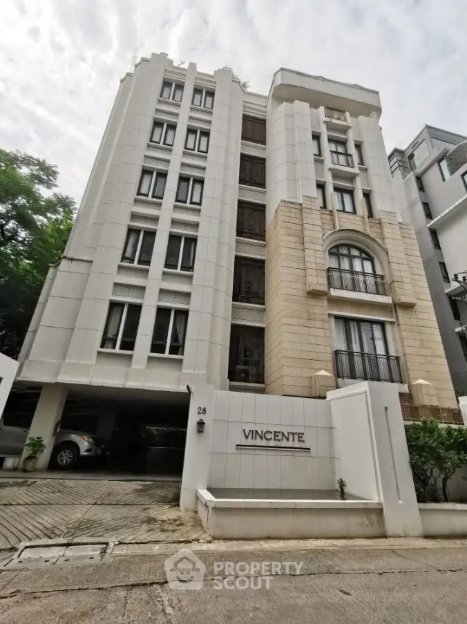 Elegant multi-story residential building with modern facade and secure parking area.