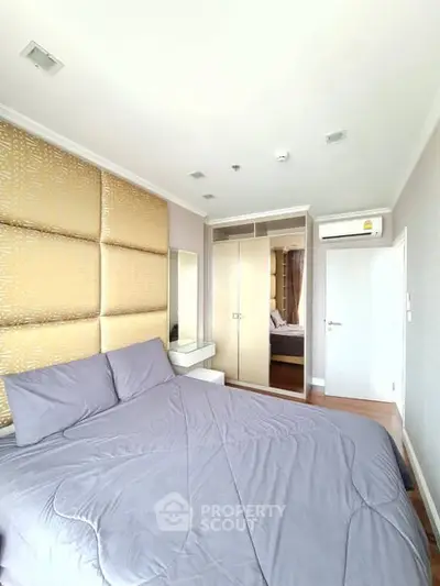 Modern bedroom with stylish decor and built-in wardrobe in a cozy apartment.