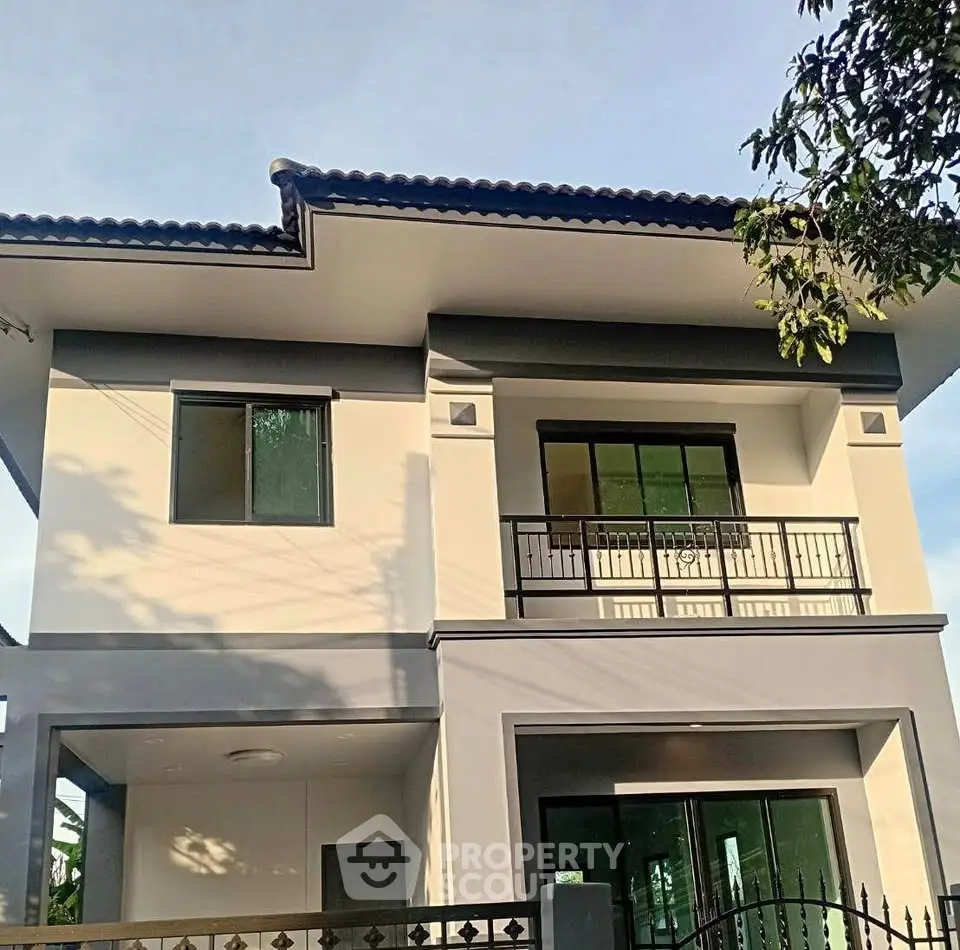 Modern two-story house with sleek design and spacious balcony, perfect for family living.