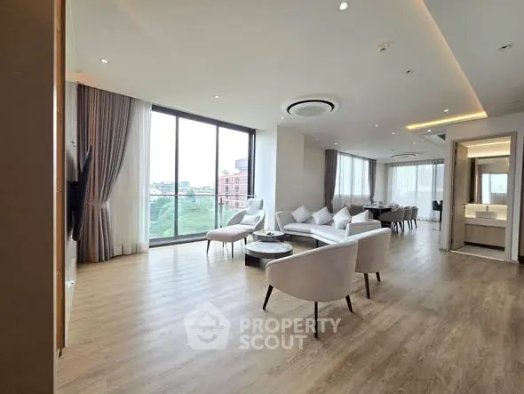 Spacious modern living room with large windows and elegant furnishings