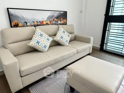 Stylish living room with modern beige sofa and vibrant artwork, perfect for cozy relaxation.