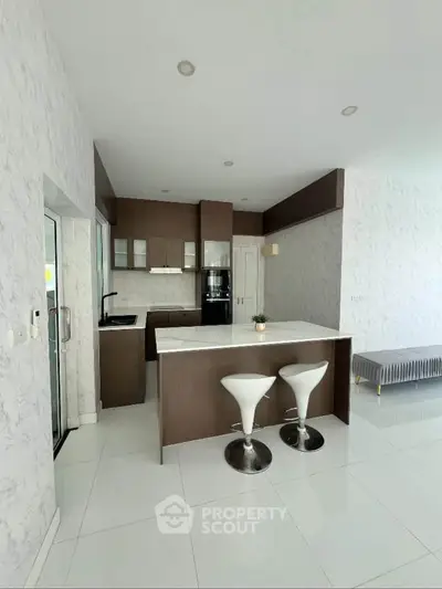 Modern kitchen with sleek design and breakfast bar in open layout apartment.