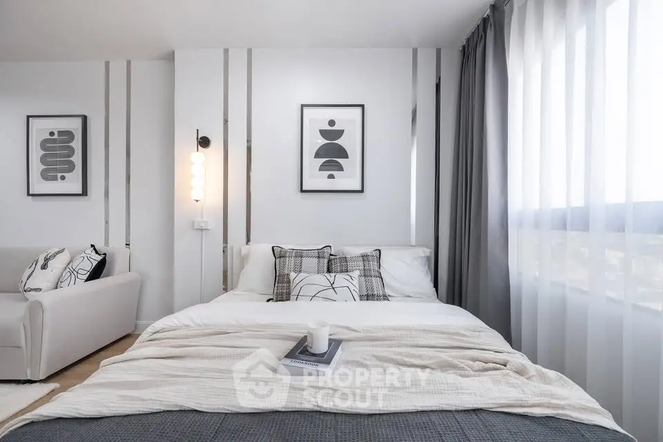 Modern bedroom with stylish decor and large window offering natural light