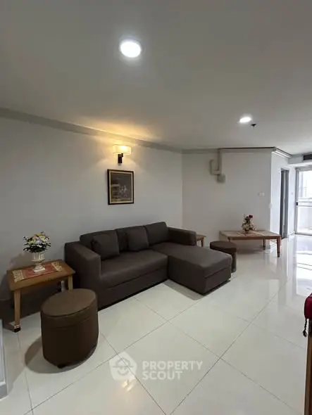 Spacious living room with modern sofa and elegant decor in a well-lit apartment.