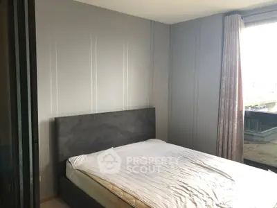 Modern bedroom with sleek design and large window offering natural light.