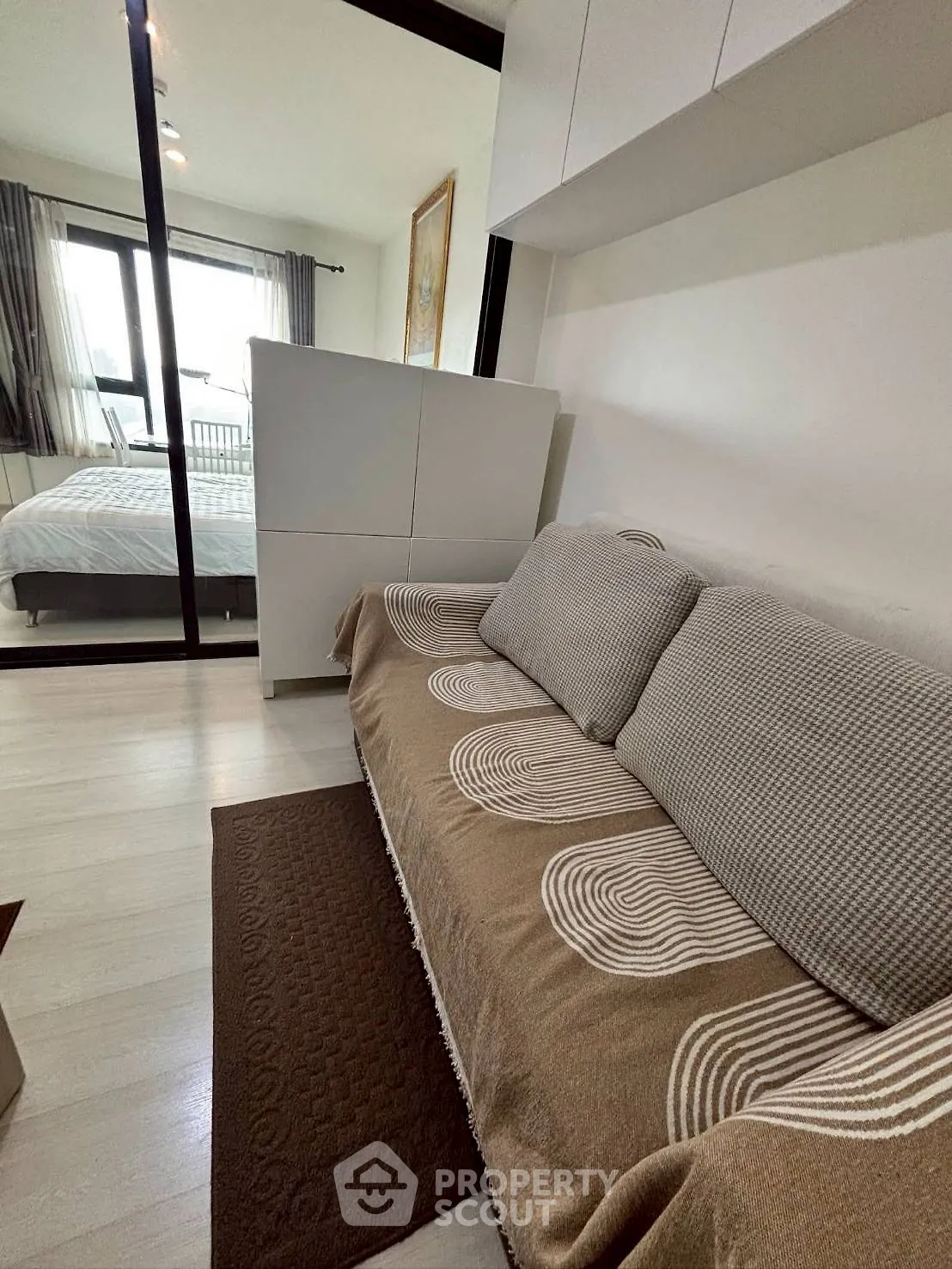 Cozy bedroom with stylish decor and large window for natural light