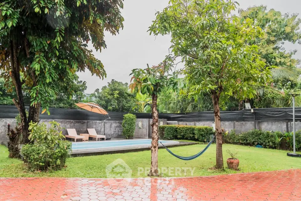 Spacious backyard with pool and hammock, perfect for relaxation and outdoor enjoyment.
