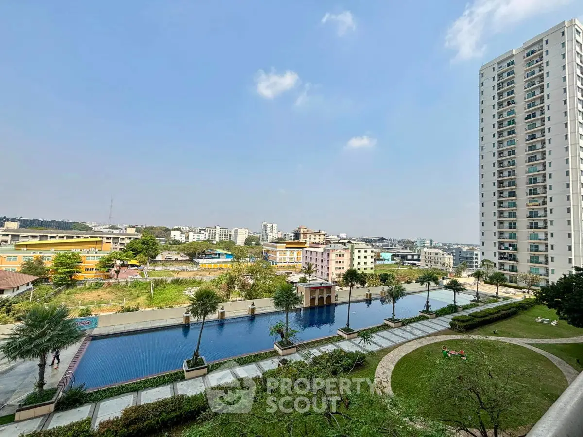 Stunning high-rise apartment with pool and garden view in vibrant urban setting.