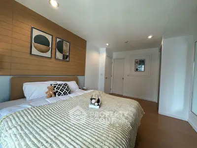 Modern bedroom with cozy decor and stylish artwork on the wall.